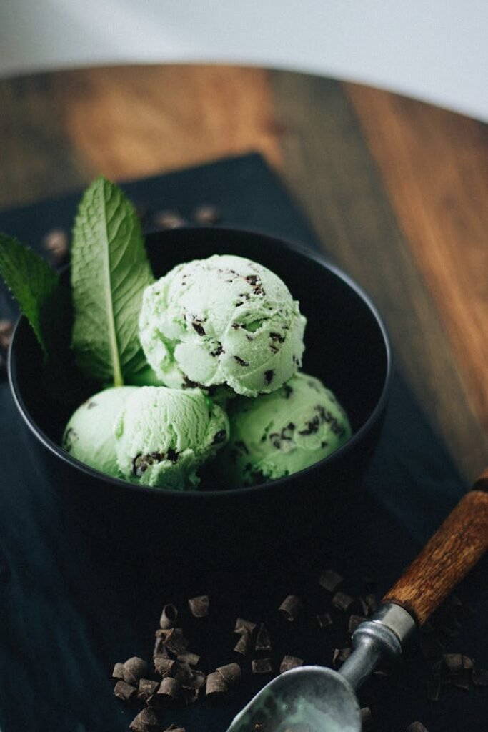 pexels-photo-29851696 Artisan mint chocolate chip ice cream with fresh mint leaves, perfect for dessert photography.